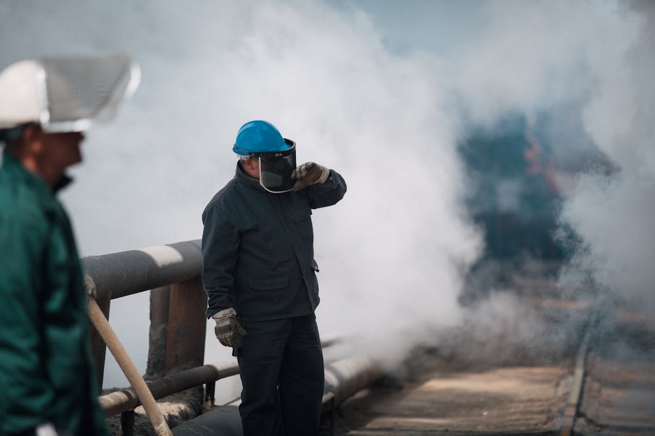 services-01 Industrial workers wearing protective gear surrounded by heavy smoke, ensuring safety in harsh environments.